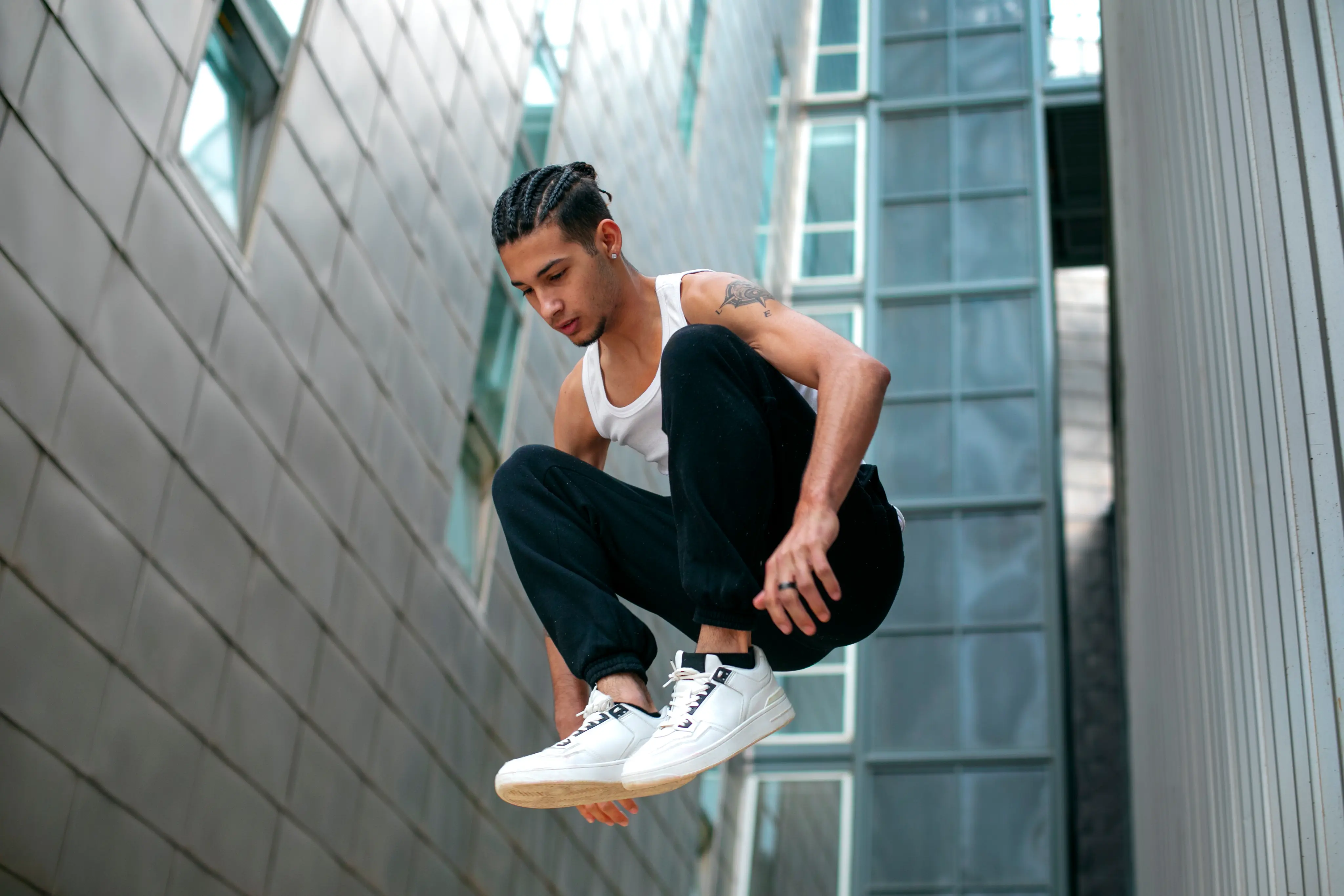 Athletic man in mid-air performing a parkour jump in an urban setting